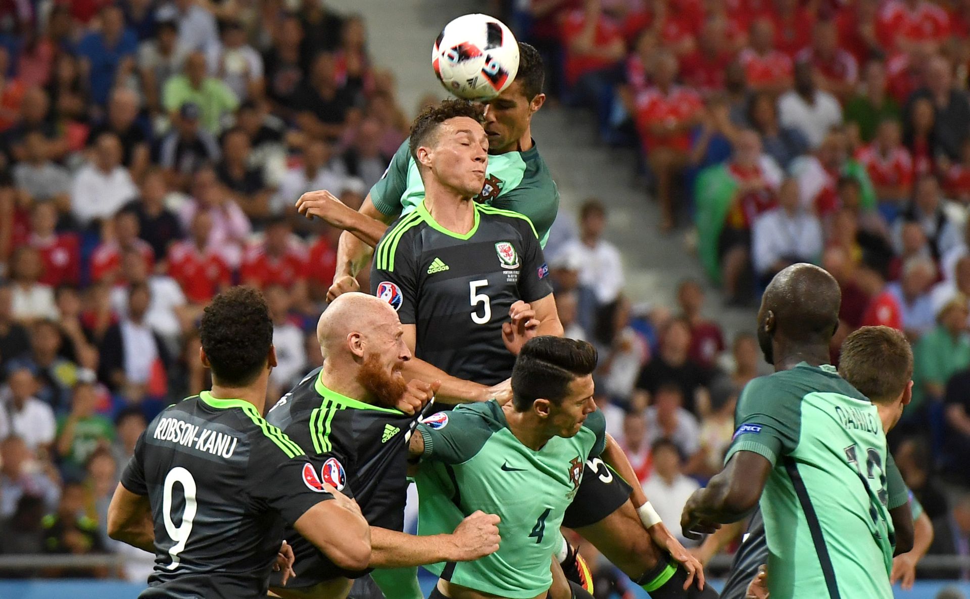 epa05411676 Cristiano Ronaldo (up) of Portugal scores the opening goal during to the UEFA EURO 2016 semi final match between Portugal and Wales at Stade de Lyon in Lyon, France, 06 July 2016.

(RESTRICTIONS APPLY: For editorial news reporting purposes only. Not used for commercial or marketing purposes without prior written approval of UEFA. Images must appear as still images and must not emulate match action video footage. Photographs published in online publications (whether via the Internet or otherwise) shall have an interval of at least 20 seconds between the posting.)  EPA/GEORGI LICOVSKI   EDITORIAL USE ONLY  EDITORIAL USE ONLY