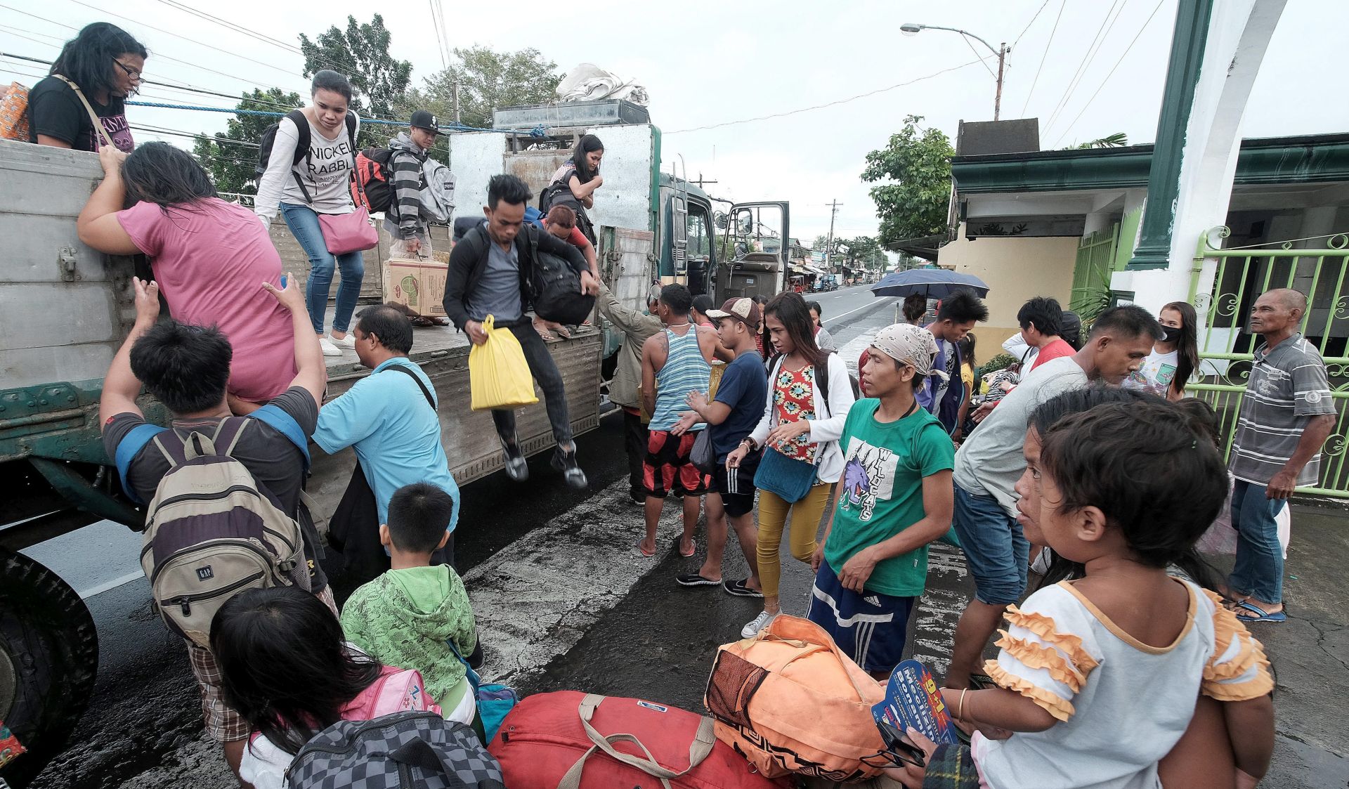 epa05687209 Filipino villagers carrying belongings board a truck during evacuation on Christmas eve in the town of Tabaco, Albay province, Philippines, 24 December 2016. According to news reports, authorities evacuated thousands in coastal villages in Bicol region where Typhoon Nock-ten is expected to make landfall on Christmas Day.  EPA/ZALRIAN SAYAT