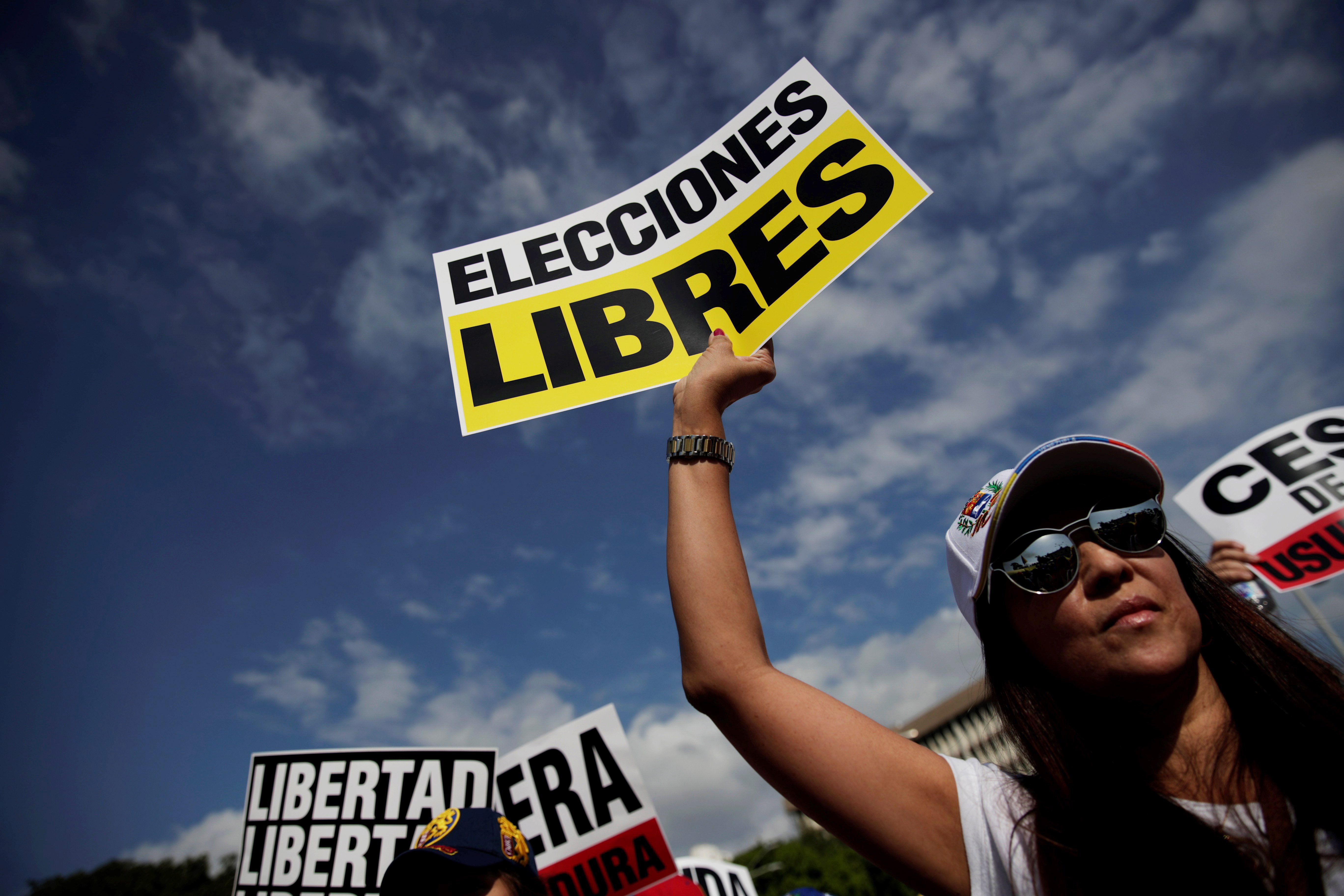 epa07339763 A woman holds a sign that reads 'Free election' during a rally to show support to President of the Venezuelan National Assembly Juan Guaido and protest against the crisis in their country, in Panama City, Panama, 02 February 2019. Venezuela's President Maduro and his opponent National Assembly leader Juan Guaido have called on their supporters to take to the streets as international pressure increased on Maduro to resign. Guiado had declared himself interim president of Venezuela on 23 January and promised to guide the country toward new election as he consider last May's election not valid.  EPA/Bienvenido Velasco