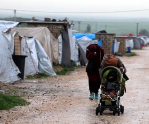 epa07473789 Unidentified women, reportedly wives of a suspected Islamic State (IS) fighter, cover their faces as they walks at Roj refugees camp in Hasakah, northeast of Syria, 30 March 2019. The camp which is controlled by the US-backed Syrian Democratic Forces (SDF) houses over 300 families, most of them are wives and children of Islamic state (IS) fighters among them foreigners who arrived in the camp following the defeat of Islamic State group in its last strongholds in eastern Syria.  EPA/AHMED MARDNLI