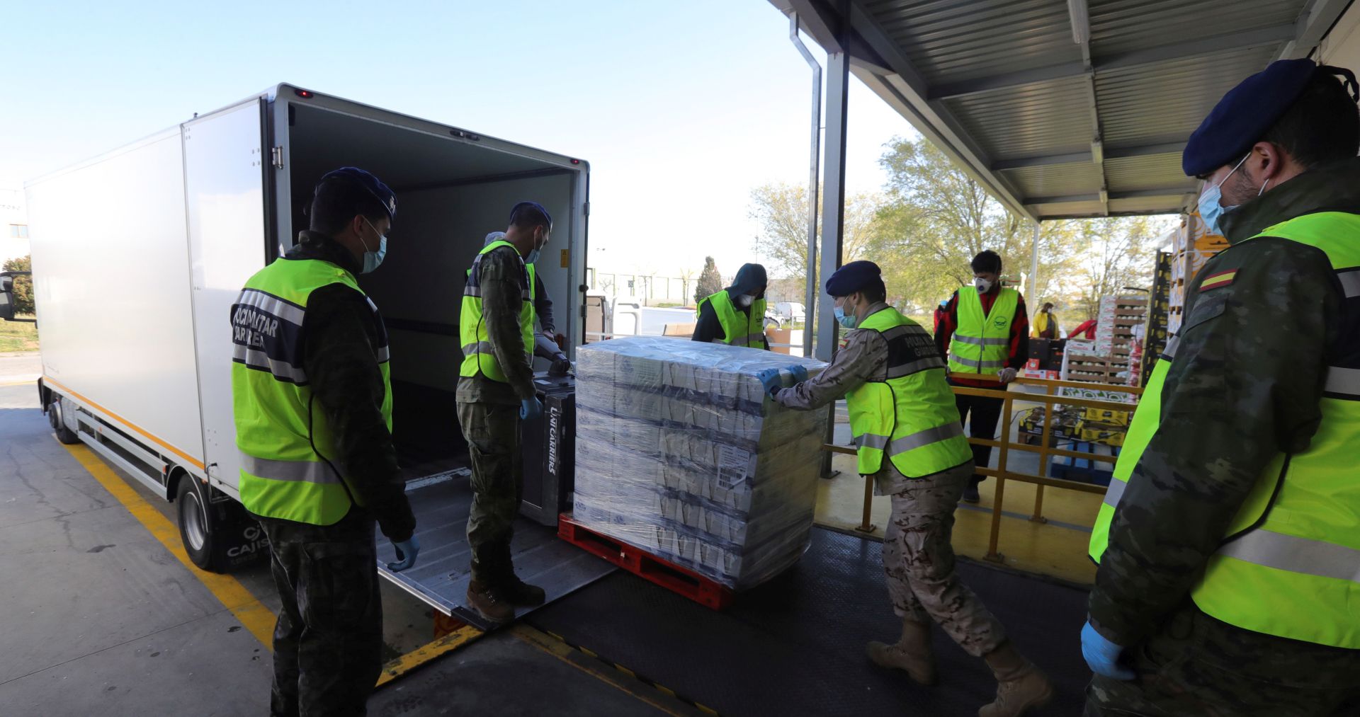 epa08340197 Soldiers of the Royal Guard help to load a truck with goods at the Food Bank of Madrid warehouse in Alcala de Henares, Madrid, Spain, 03 April 2020. The Food Bank of Madrid is still working, despite the coronavirus crisis, to supply all those entities helping people in need. Spain faces the 20th consecutive day of mandatory home confinement in a bid to slow down the spread of the pandemic COVID-19 disease caused by the SARS-CoV-2 coronavirus.  EPA/JUANJO MARTIN