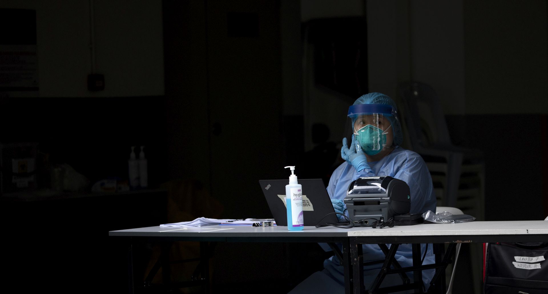 epa08384726 Medical staff in personal protective equipment (PPE) prepare migrant workers to be tested for the COVID-19 disease at Westlite Toh Guan foreign workers dormitory, which has been gazetted as an isolation area to prevent the spread of new infections, in Singapore, 26 April 2020. Singapore is experiencing a surge in new coronavirus and COVID-19 disease cases, where migrant workers living in dormitories made up most of the new infections.  EPA/HOW HWEE YOUNG