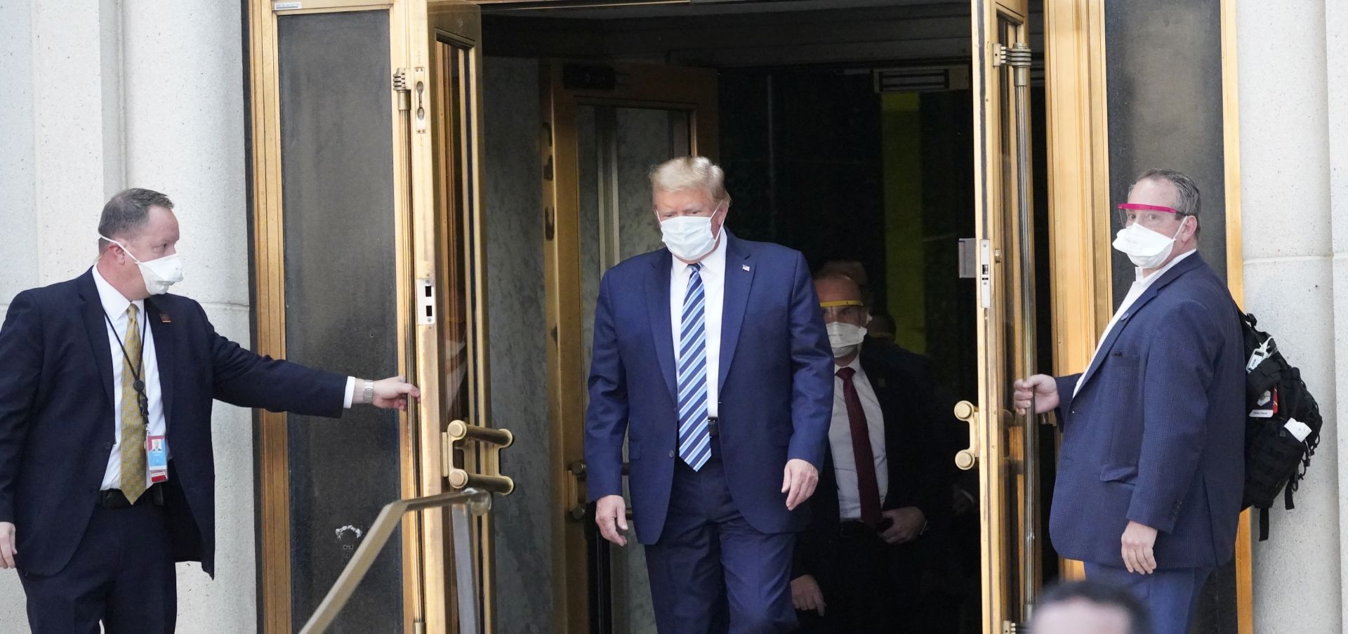 epa08723009 US President Donald J. Trump, wearing a mask, emerges from the front door of Walter Reed National Military Medical Center, in Bethesda, Maryland, USA, 05 October 2020, to board Marine One for a return trip to the White House after receiving treatment for a COVID-19 infection.  EPA/Chris Kleponis / POOL