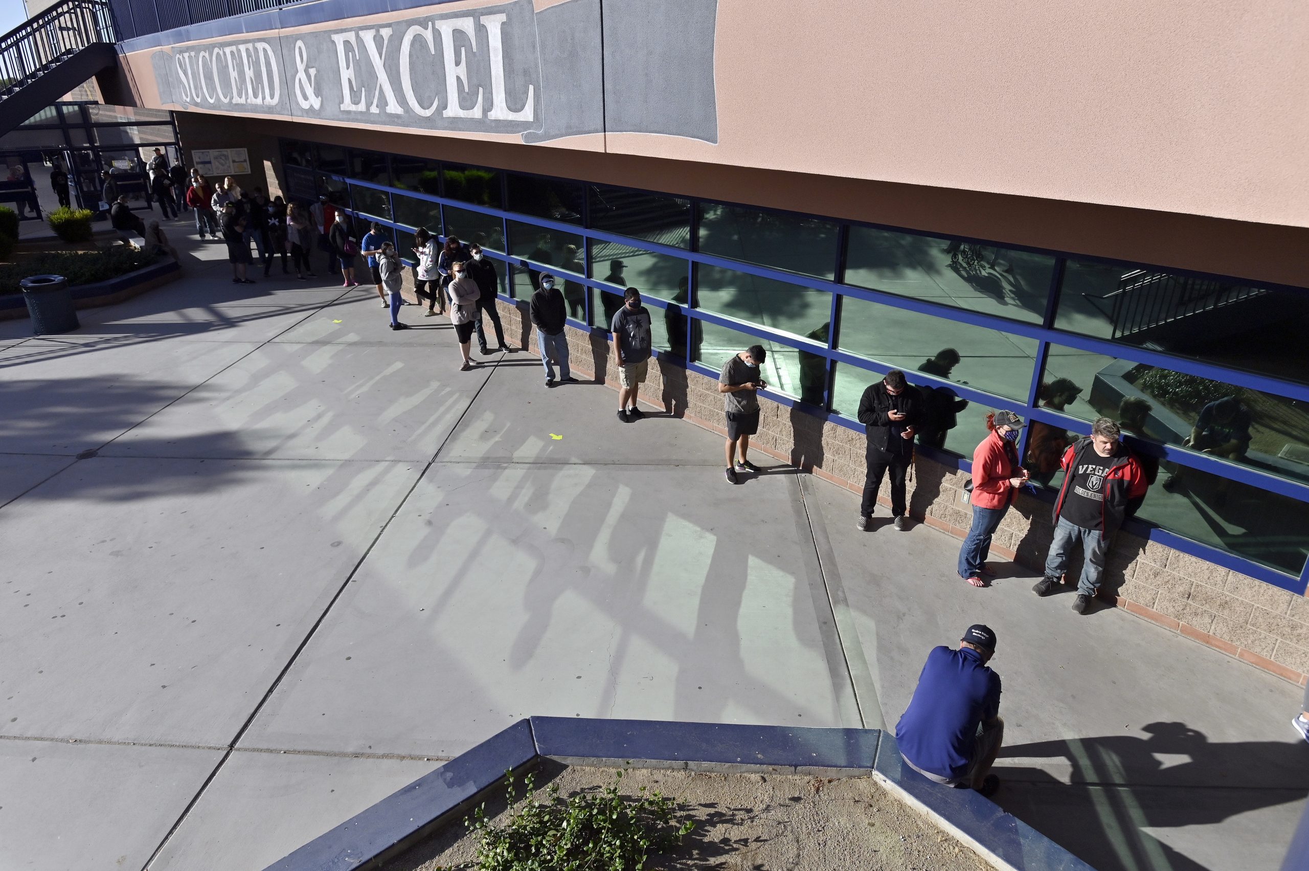 epa08795916 Voters line up prior to the opening of the polls at Shadow Ridge High School in Las Vegas, Nevada, USA, 03 November 2020. Americans vote on Election Day to choose between re-electing Donald J. Trump or electing Joe Biden as the 46th President of the United States to serve from 2021 through 2024.  EPA/DAVID BECKER