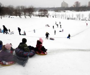 epa08920877 Children slide down a hill during the Christmas holidays in Moscow, Russia, 05 January 2021. Russians are preparing to celebrate the Christmas which is observed on 07 January according to the Russian Orthodox Julian calendar, 13 days after Christmas on 25 December on the Gregorian calender.  EPA/MAXIM SHIPENKOV