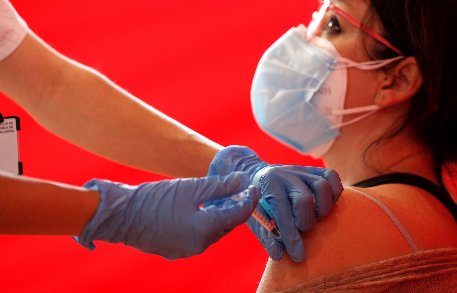 epa09099960 A health worker injects a dose of the AstraZeneca vaccine against COVID19 to a teacher, in Valencia, eastern Spain, 26 March 2021. Spain resumed the use of this vaccine after a 10-day-long pause in its administration after reports stated the vaccine could be associated with an increase in the risk of blood clotting disorders, doubts that were finally ruled out by the European Union's medicines regulator that declared the vaccine as safe.  EPA/Manuel Bruque