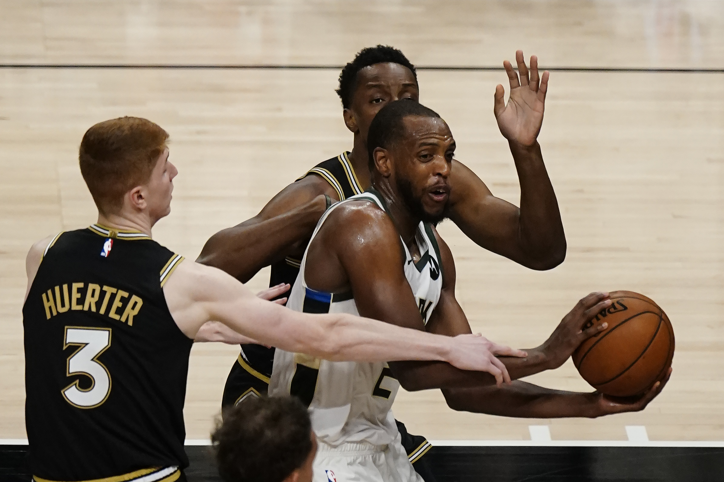 Milwaukee Bucks forward Khris Middleton (22) tries to get past Atlanta Hawks guard Kevin Huerter (3) during the second half of their NBA Eastern Conference Finals playoff series basketball game Saturday, July 3, 2021, in Atlanta. (AP Photo/John Bazemore)