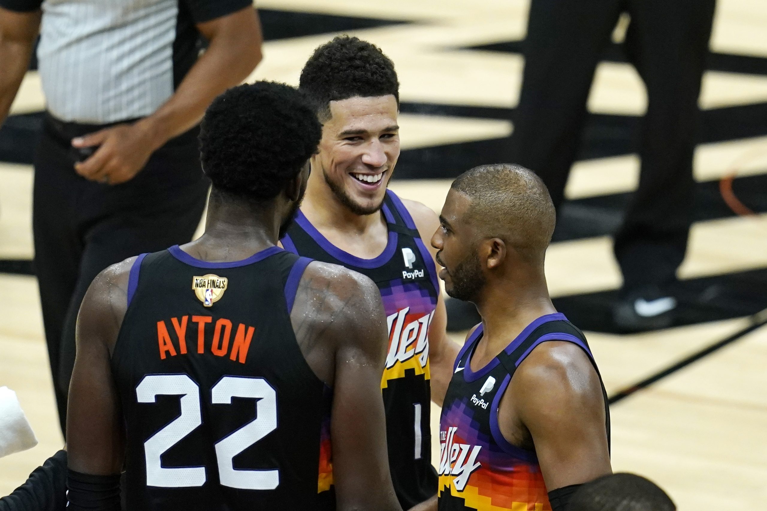 Phoenix Suns' Deandre Ayton (22), Booker, middle, Chris Paul, right, celebrate after Game 1 of basketball's NBA Finals against the Milwaukee Bucks, Tuesday, July 6, 2021, in Phoenix. The Suns defeated the Bucks 118-105. (AP Photo/Ross D. Franklin)