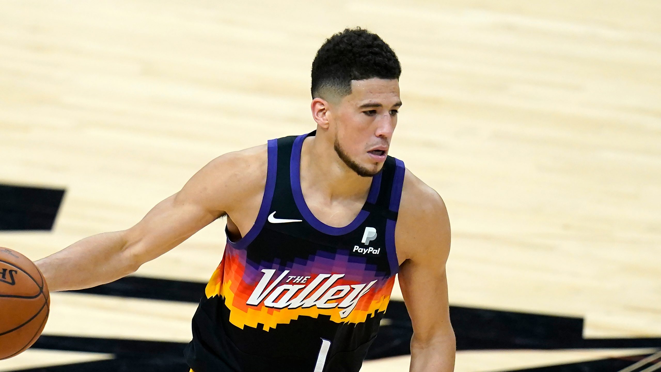 Phoenix Suns guard Devin Booker dribbles the ball against the Milwaukee Bucks during the second half of Game 1 of basketball's NBA Finals, Tuesday, July 6, 2021, in Phoenix. The Suns defeated the Bucks 118-105. (AP Photo/Ross D. Franklin)