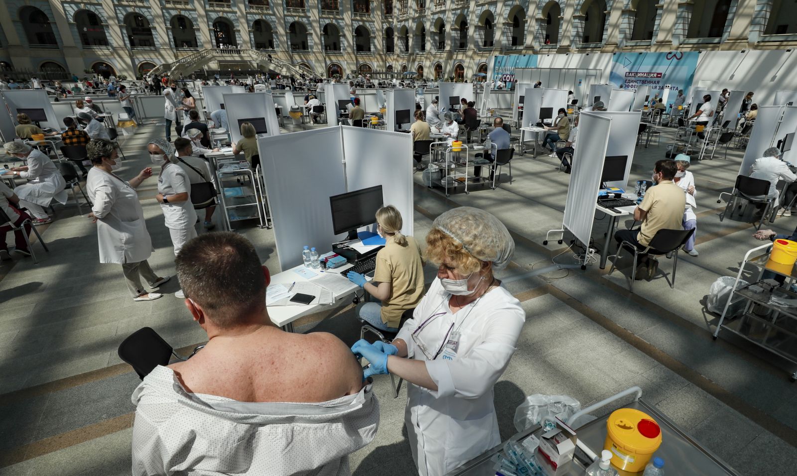 epa09325495 A man receives a shot of Russia's Sputnik V vaccine against COVID-19 disease at a vaccination center in Gostinny Dvor, a huge exhibition place in Moscow in Moscow, Russia, 06 July 2021. Moscow being the epicenter of the new outbreak of the infectious by the new Delta variant. Moscow authorities imposed a ban to serve people without QR-codes confirming vaccination against Covid-19 at public caterings, including people recovering from coronavirus Covid-19 disease within six months before the visit, or negative PCR test taken no earlier than 72 hours before the visit.  EPA/YURI KOCHETKOV