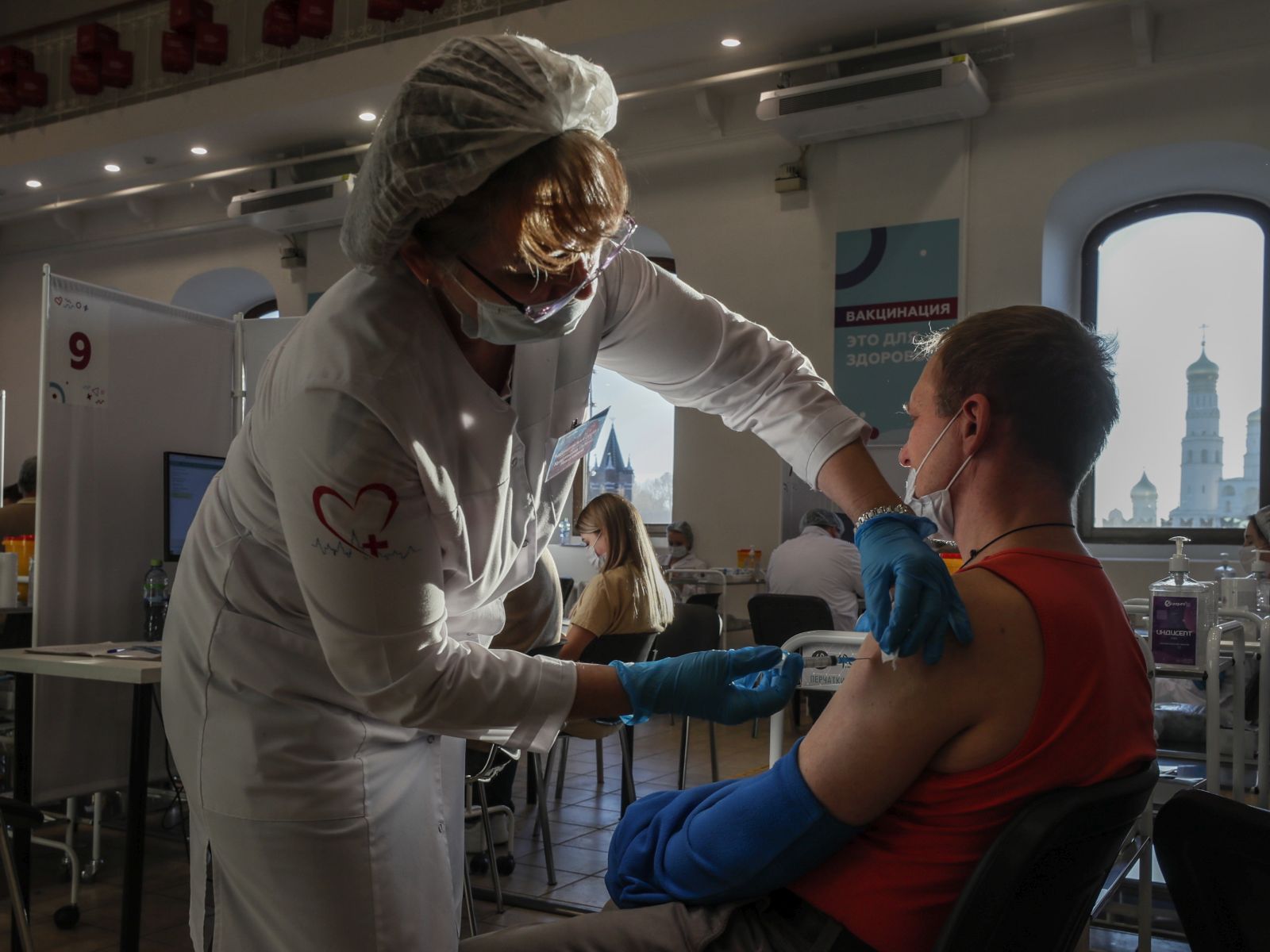 epa09557799 A man receives a shot of Russia's Sputnik V COVID-19 vaccine at a vaccination point at the State Department Store GUM, in Moscow, Russia, 01 November 2021. Authorities approved non-working week from 28 October to 07 November in Russia to curb the fast spreading of coronavirus disease (COVID-19) infections. Restrictions are also put in place during the non-working week, such as the closure of shopping malls, beauty salons, fitness centers and car services. However, pharmacies, hospitals, food stores, museums and theaters will stay open. Cafes and restaurants will only open for takeout and delivery orders.  EPA/YURI KOCHETKOV