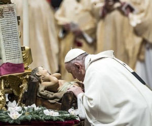 epa09669149 Pope Francis kisses a figurine of the Christ Child as he celebrates Holy Mass for the Solemnity of the Epiphany of the Lord, in the Saint Peter's Basilica in Vatican City, 06 January 2022.  EPA/ANGELO CARCONI