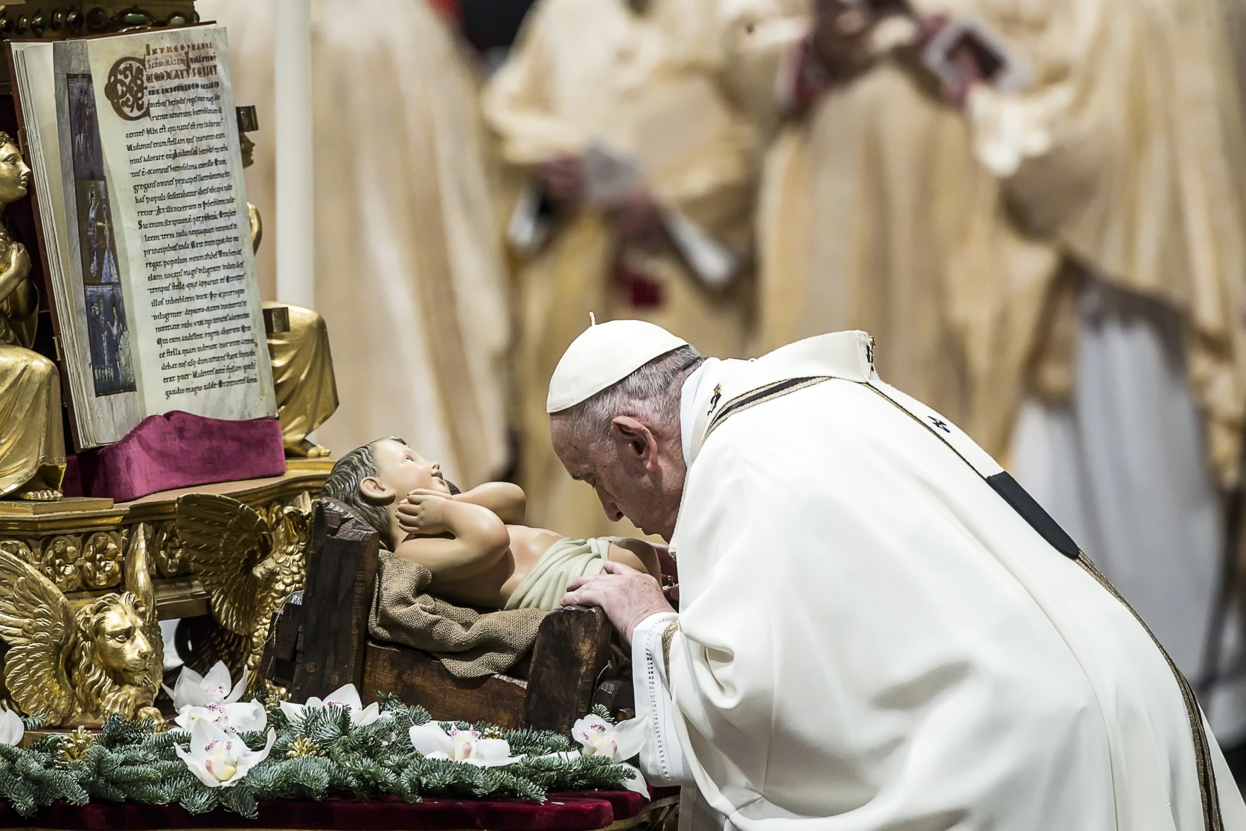 epa09669149 Pope Francis kisses a figurine of the Christ Child as he celebrates Holy Mass for the Solemnity of the Epiphany of the Lord, in the Saint Peter's Basilica in Vatican City, 06 January 2022.  EPA/ANGELO CARCONI