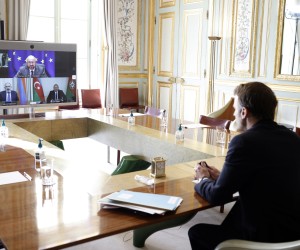 epa09727524 French President Emmanuel Macron (L) holds a video conference meeting with Armenian Prime Minister Nikol Pachinian (screen, L), Azerbaijan President Ilham Aliev (screen, R) and European Council President Charles Michel (screen, up) at the Elysee Palace in Paris, France, 04 February 2022.  EPA/YOAN VALAT / POOL