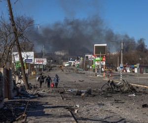 epa09814869 Residents coming from Bucha town, which is currently controlled by the Russian military, walk with luggage past a body of a dead man towards the Ukrainian checkpoint, at the frontline in Irpin town, Kyiv (Kiev) region, Ukraine, 10 March 2022. Thousands of residents are feeling Irpin and Bucha, as well as other settlements near Kyiv which were the most affected by the Russian army invasion.  EPA/ROMAN PILIPEY ATTENTION EDITORS: GRAPHIC CONTENT