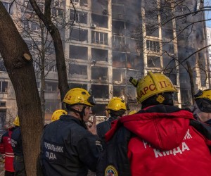 epa09826003 Rescue workers stand in front of a burning residential building which was hit by artillery shelling, in Kyiv, Ukraine, 15 March 2022. Russian troops entered Ukraine on 24 February prompting the country's president to declare martial law and triggering a series of announcements by Western countries to impose severe economic sanctions on Russia.  EPA/ROMAN PILIPEY