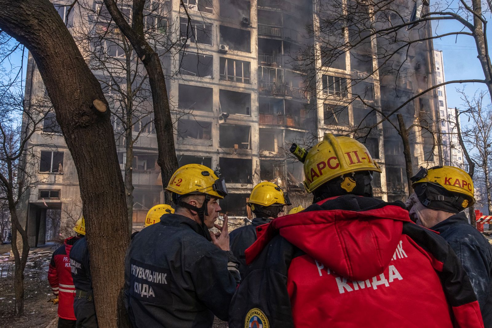 epa09826003 Rescue workers stand in front of a burning residential building which was hit by artillery shelling, in Kyiv, Ukraine, 15 March 2022. Russian troops entered Ukraine on 24 February prompting the country's president to declare martial law and triggering a series of announcements by Western countries to impose severe economic sanctions on Russia.  EPA/ROMAN PILIPEY