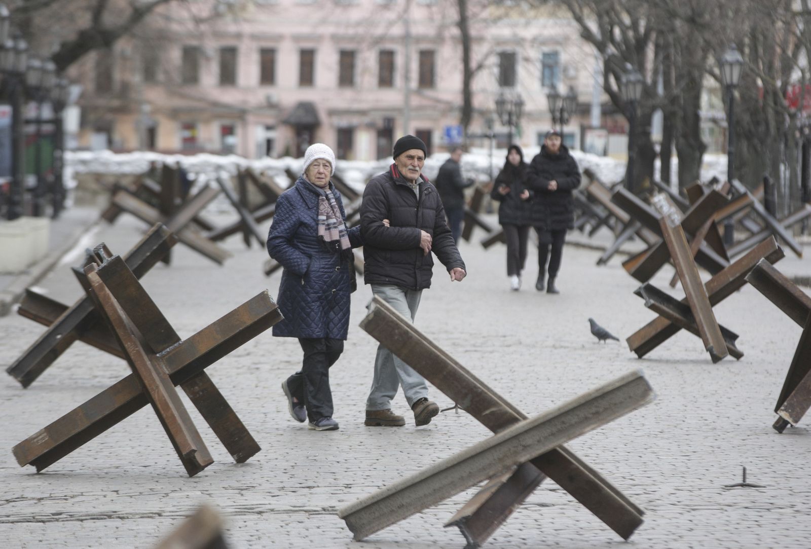 epa09829344 Locals walk on a street between anti-tank Czech hedgehogs in the South Ukrainian city of Odesa, 16 March 2022. On 24 February Russian troops had entered Ukrainian territory in what the Russian president declared a 'special military operation', resulting in fighting and destruction in the country, a huge flow of refugees, and multiple sanctions against Russia.  EPA/STEPAN FRANKO