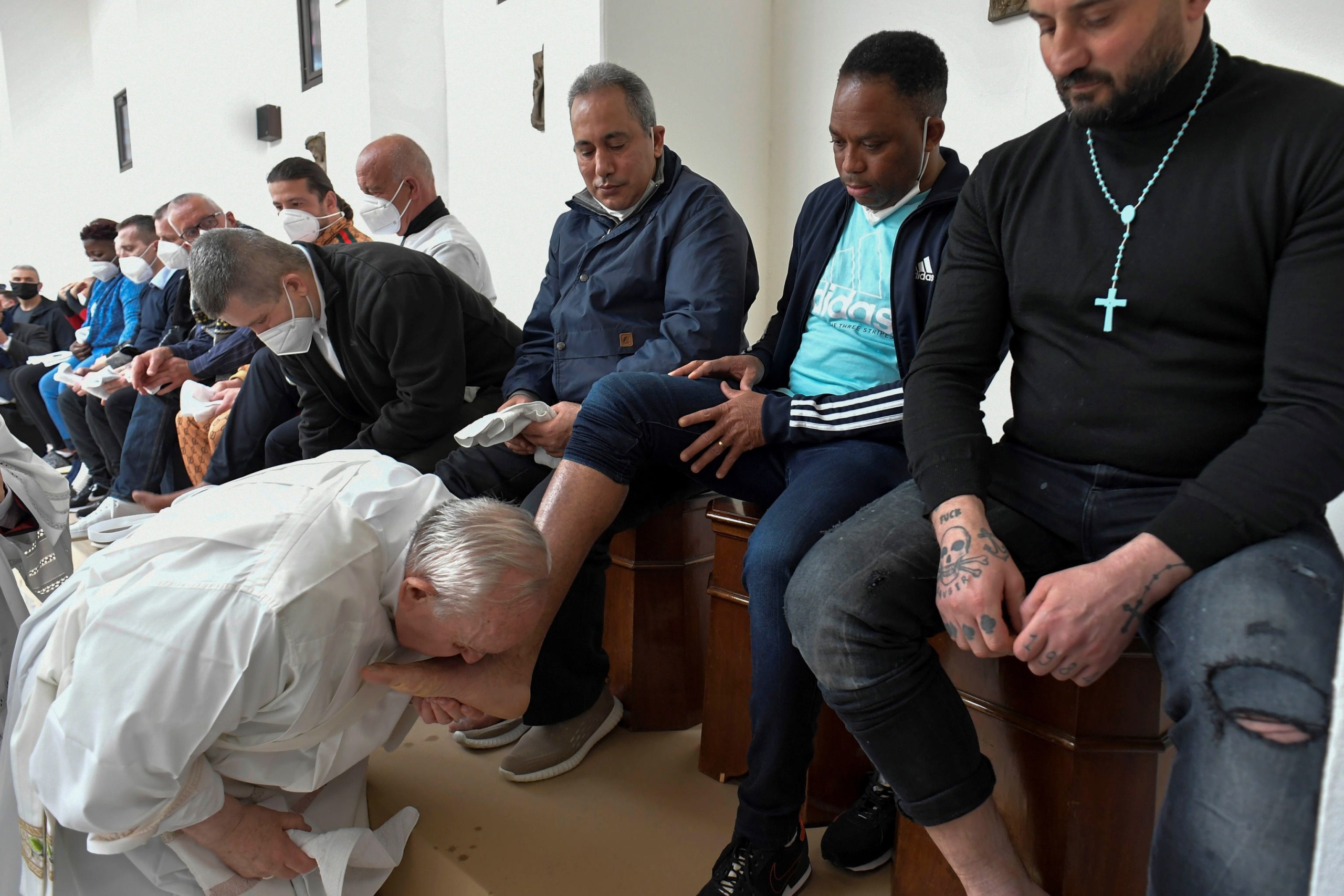 epa09890137 A handout picture provided by the Vatican Media shows Pope Francis (L) kisses an inmate's feet inside the prison of Civitavecchia, near Rome, where on Holy Thursday he makes a private visit during which he celebrates mass "'n coena Domini' with the traditional rite of 'washing of the feet' of 12 inmates, in Civitavecchia, Italy, 14 April 2022.  EPA/VATICAN MEDIA HANDOUT  HANDOUT EDITORIAL USE ONLY/NO SALES