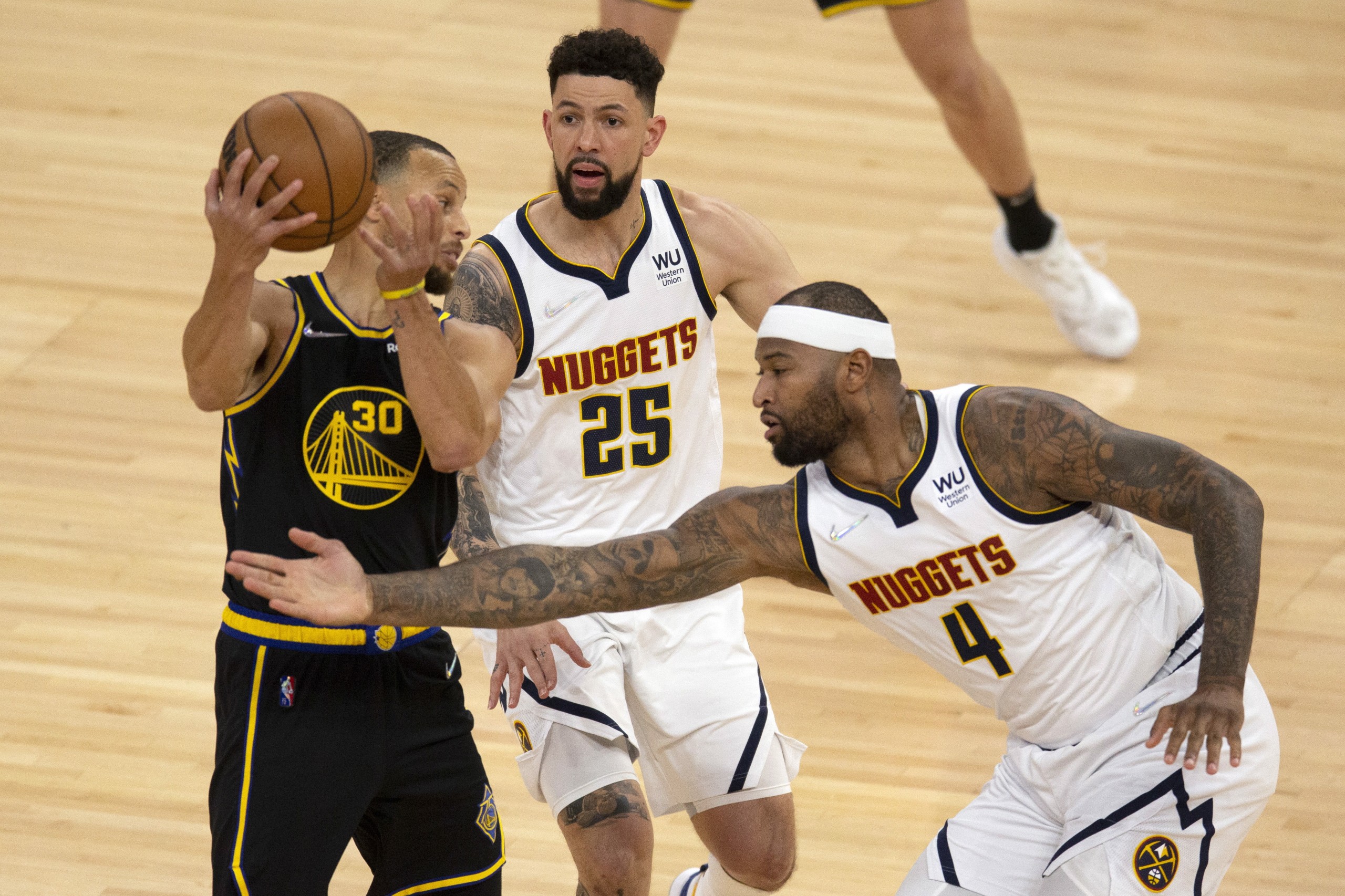 epa09894087 Golden State Warriors guard Stephen Curry (L) looks to pass around Denver Nuggets defenders Austin Rivers (C) and DeMarcus Cousins during the first quarter of the NBA basketball game between the Denver Nuggets and the Golden State Warriors at Chase Center in San Francisco, California, USA, 16 April 2022.  EPA/D. ROSS CAMERON  SHUTTERSTOCK OUT