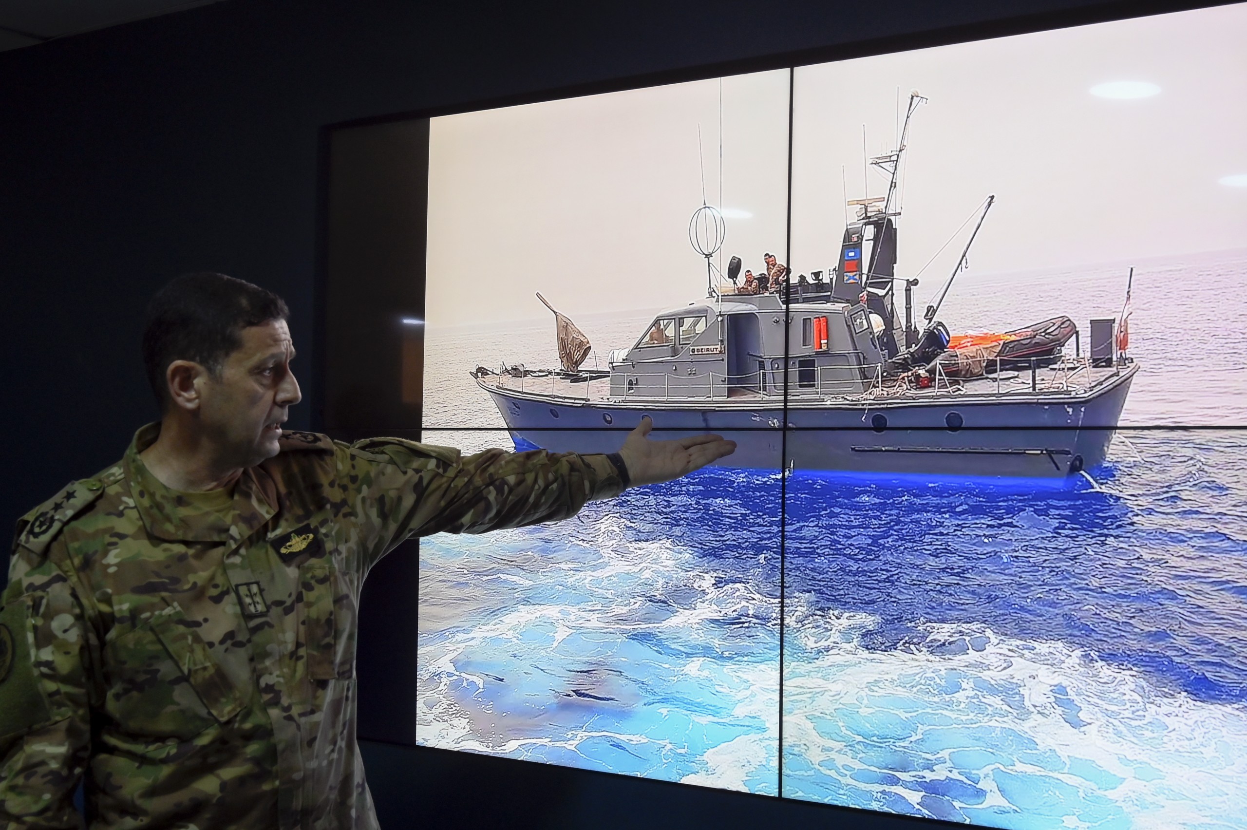 epa09906578 Commander of the Naval Forces, Colonel Naval Haitham Dnawy, points at a picture of a Lebanese navy ship as he speaks during a press conference explaining the circumstances of the boat that sank off the coast of Tripoli in North Lebanon, at the Naval Base in Beirut, Lebanon, 24 April 2022. According to Dnawy, 45 people were saved and 6 bodies were found, including that of a young girl, after a boat carrying nearly 60 illegal migrants out of Lebanon sank near the northern city of Tripoli. The boat capsized after its captain tried to evade Lebanese navy ships attempting to stop him which resulted in him crashing in a Lebanese navy ship.  EPA/WAEL HAMZEH