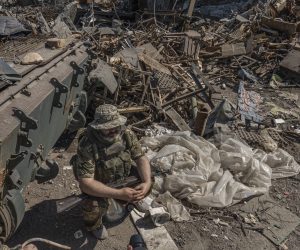 epa10011297 A picture taken during a visit to Mariupol organized by the Russian military shows a self-proclaimed Donetsk People Republic militia on guard at the destroyed entrance of the Azovstal steel plant in Mariupol, eastern Ukraine, 13 June 2022. According to a statement by the Ukrainian Presidential Office on 06 June quoting President Zelensky, there may be more than 2,500 prisoners from the Azovstal plant being held captive by Russian forces. On 24 February Russian troops entered Ukrainian territory starting a conflict that has provoked destruction and a humanitarian crisis.  EPA/SERGEI ILNITSKY