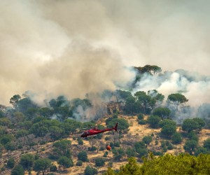 epa10082044 A firefighting helicopter flies over the fire in Cebreros Avila, Spain, 20 July 2022. The fire that started Saturday 17 has burned over 3,000 hectares so far.  EPA/RAUL SANCHIDRIAN