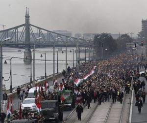 epa10259145 Young people hold torches and wave national flags as they ride and follow old, historical trucks during a march from the Budapest University of Technology and Economics through the streets of Budapest, Hungary, to re-enact the protest march of Hungarian students in 1956 which ignited the revolution and war of independence against communist rule and the Soviet Union, 22 October 2022, the eve of the 66th anniversary of the outbreak of the 1956 revolution in Hungary.  EPA/Tamas Kovacs HUNGARY OUT