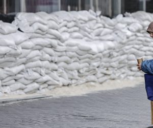 epa10268571 A woman begs for money in front of a barricade of sandbags in Dnipro, Ukraine, 27 October 2022. Russian troops on 24 February entered Ukrainian territory, starting a conflict that has provoked destruction and a humanitarian crisis.  EPA/HANNIBAL HANSCHKE