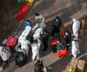 epa10326874 Volunteer health workers wear protective clothing outside of a Unit building with confirmed case in Beijing, China, 25 November 2022. According to the National Health Commission report on 25 November, over 1000 new locally transmitted COVID-19 cases were detected in Beijing, stricter COVID-19 prevention measures have been implemented by the local government and many communities with confirmed cases have been blocked.  EPA/WU HAO