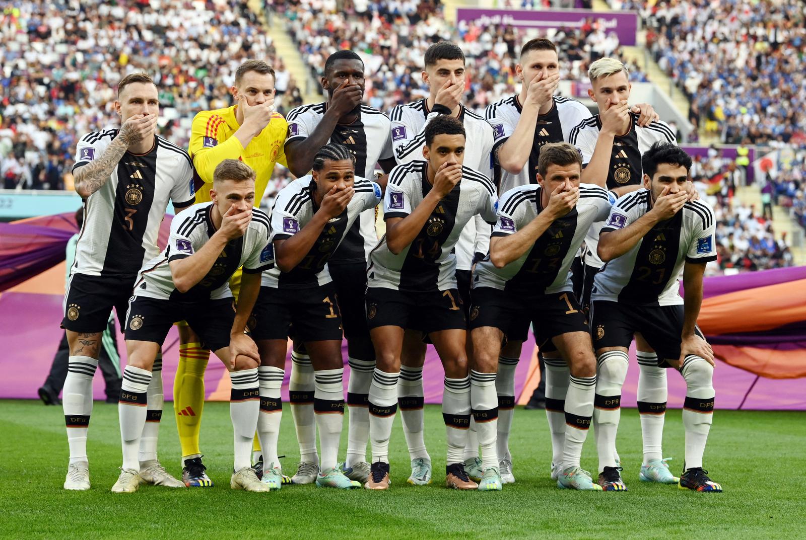 Soccer Football - FIFA World Cup Qatar 2022 - Group E - Germany v Japan - Khalifa International Stadium, Doha, Qatar - November 23, 2022 Germany players cover their mouths as they pose for a team group photo before the match REUTERS/Annegret Hilse     TPX IMAGES OF THE DAY Photo: Annegret Hilse/REUTERS