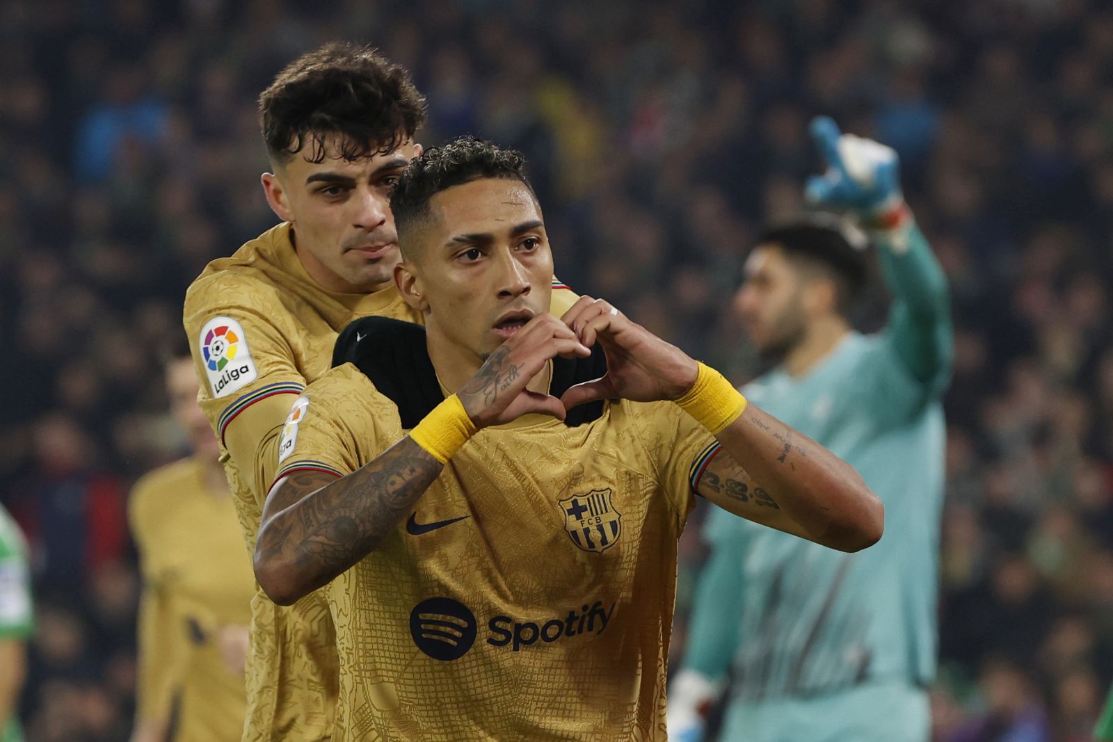 epa10443414 FC Barcelona's Raphinha (R) celebrates after scoring the 0-1 goal during the LaLiga match between Real Betis and FC Barcelona, in Seville, southern Spain, 01 February 2023.  EPA/Julio Munoz