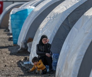 epa10475480 A woman affected by the earthquake sits next to her son inside a tent camp in Iskenderun district of Hatay, Turkey, 18 February 2023. More than 45,000 people have died and thousands more are injured after two major earthquakes struck southern Turkey and northern Syria on 06 February. Authorities fear the death toll will keep climbing as rescuers look for survivors across the region.  EPA/SEDAT SUNA