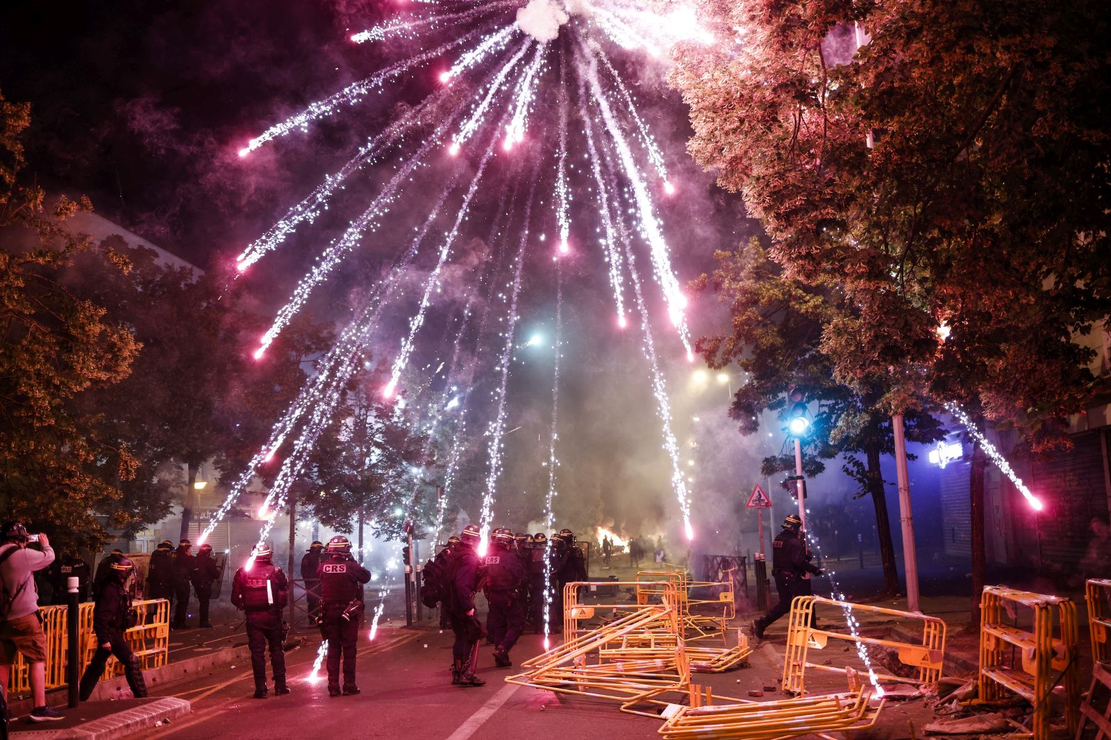 epa10716123 Protesters throw fireworks at riot police during clashes in Nanterre, near Paris, France, 29 June 2023. Violence broke out after police fatally shot a 17-year-old during a traffic stop in Nanterre on 27 June 2023. According to the French interior minister, 31 people were arrested with 2,000 officers being deployed to prevent further violence.  EPA/YOAN VALAT