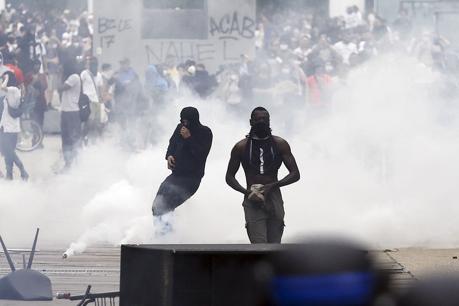 epa10717580 Protesters stand amid tear gas during clashes with French riot police following a march in the memory of 17-year-old Nahel, who was killed by French Police in Nanterre, near Paris, France, 29 June 2023. Violence broke out after the police fatally shot a 17-year-old during a traffic stop in Nanterre on 27 June. According to the French interior minister, 31 people were arrested with 2,000 officers being deployed to prevent further violence.  EPA/YOAN VALAT