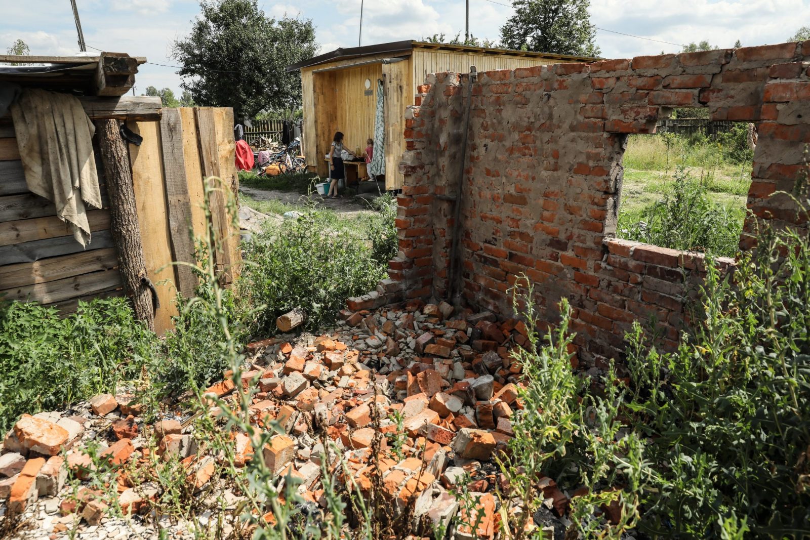 epa10733789 A view of the family destroyed home (Foreground) as siblings Julia and Vita play near their family's temporary module shelter (Background) at Kukhari village, Kyiv Region, Ukraine, 05 July 2023 (issued 08 July 2023). The village of Kukhari is located some 100 km north of Kyiv. Before the war there were 463 households, 78 of them were destroyed during active combat in the region. One of these was Zaritsky's family house. On 10 March 2022, Igor Zaritsky (39), his wife Olga (37), and their three children, Julia (16), Yehor (10) and Vita (3), hid from shelling in the basement of their house, when it was damaged and began to burn. Their neighbor helped Olga and the children to escape to the nearby village of Zarudddia, where Igor found them the next day. Later they traveled to Malyn, Zhytomyr, Zviahil, stopping at relatives and friends' places. After the Russian army was forced out from the Kyiv region in April 2022, the local population slowly returned to their villages. The Zaritsky family returned to their home on 08 May. Near their destroyed house, they built a makeshift shelter, where they spent the summer. Later in Autumn, they moved to a temporary module house, given to them as humanitarian aid, where they spent one winter. Step by step, they try to manage their life in the unusual conditions and rebuild a house for them to return to a more normal life. They bought a horse they named Javelina (Olyk, the horse they previously had was killed in a shelling), and are waiting for a possible humanitarian grant, to buy a cow which can cost as much as 1000 euros. Their two elder children attend school online since the war started, on top of their home, the school had also been destroyed in a shelling, they are now on summer vacations so they help their parents to care for their younger sibling, and with the household chores. Igor, the dad, works as a forester, his wife Olga who used to work as a post office Manager, is now a stay at home mum, sometimes doing