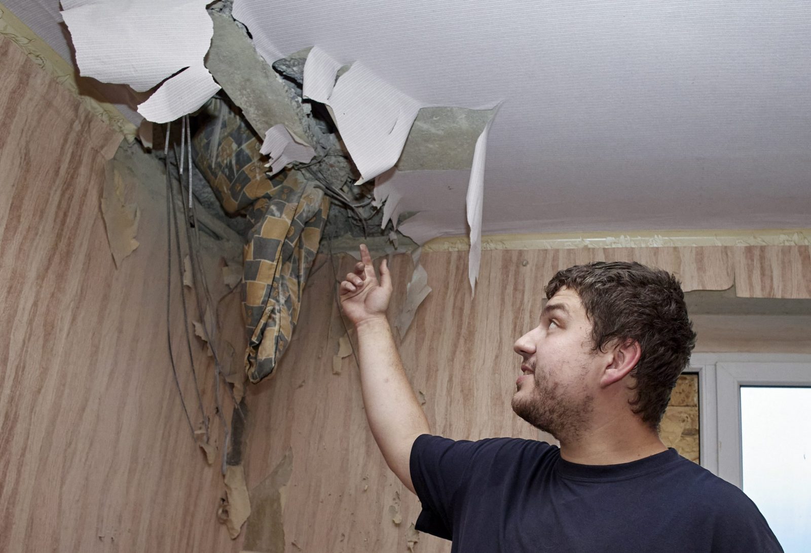 epa10733940 Local resident Mikhail shows a damaged room in his flat which was hit by a missile strike in the firsts days of the war with Russia, in the Piatykhatky settlement of Kharkiv, northeastern Ukraine, 04 July 2023 (issued 08 July 2023). Twenty six years old Mikhail, narrowly escaped death when one of the first rockets of the war with Russia  on 24 February 2022, fell very close to where he slept, in the flat his mother and him were sharing. The rocket, described by emergency services as a self-propelled 122 mm multiple rocket BM-21 Grad system had entered the flat through the ceiling; its front part ended up awkwardly buried in a hole right next to his bed. He realized only later how lucky he was that morning that the rocket had not exploded on impact. Emergency services came to retrieve the rocket but Mikahil and his mother, who moved to his  grandmother's flat not far from their old one meanwhile, are still waiting to receive help to repair their damaged home as promised by local authorities. Before the war, the young man had been a student of the National Automobile Highway University, and now works at an auto service. His salary is enough to support himself and family but not enough to repair his old flat, he received 600 euros of the promised help but the rest has not materialized yet.The war in Ukraine which started when Russian troops entered Ukraine in February 2022, marks on 08 July its 500th day.  According to the UN more than 9000 civilians have been killed since the war started.  EPA/SERGEY KOZLOV