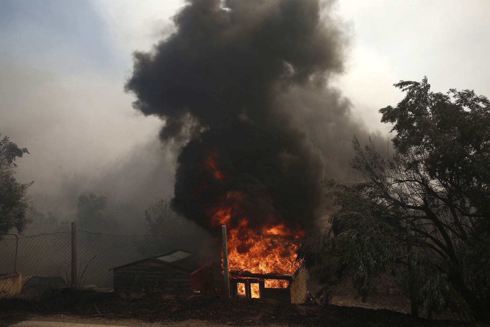 epa10751951 A house is on fire during a wildfire at Lagonisi area, Greece, 17 July 2023. Firefighting forces are battling a blaze that broke out in the Kouvaras area in Attica, while a warning was sent via the emergency number 112 to evacuate several settlements in southeast Attica. A force of 55 firefighters and 20 fire engines, two units on foot and 31 Romanian firefighters with five water tankers have been deployed to put out the fire, assisted by six fire-fighting aircraft and four helicopters from the air.  EPA/YANNIS KOLESIDIS