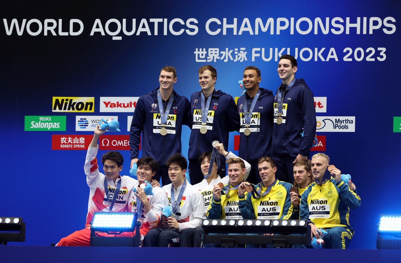 epa10777390 Gold medalists team USA (top) pose with silver medalists team China (front L) and bronze medalists team Australia at the medal ceremony of the Men's 4 x 100m Medley Relay of the Swimming events during the World Aquatics Championships 2023 in Fukuoka, Japan, 30 July 2023.  EPA/KIYOSHI OTA