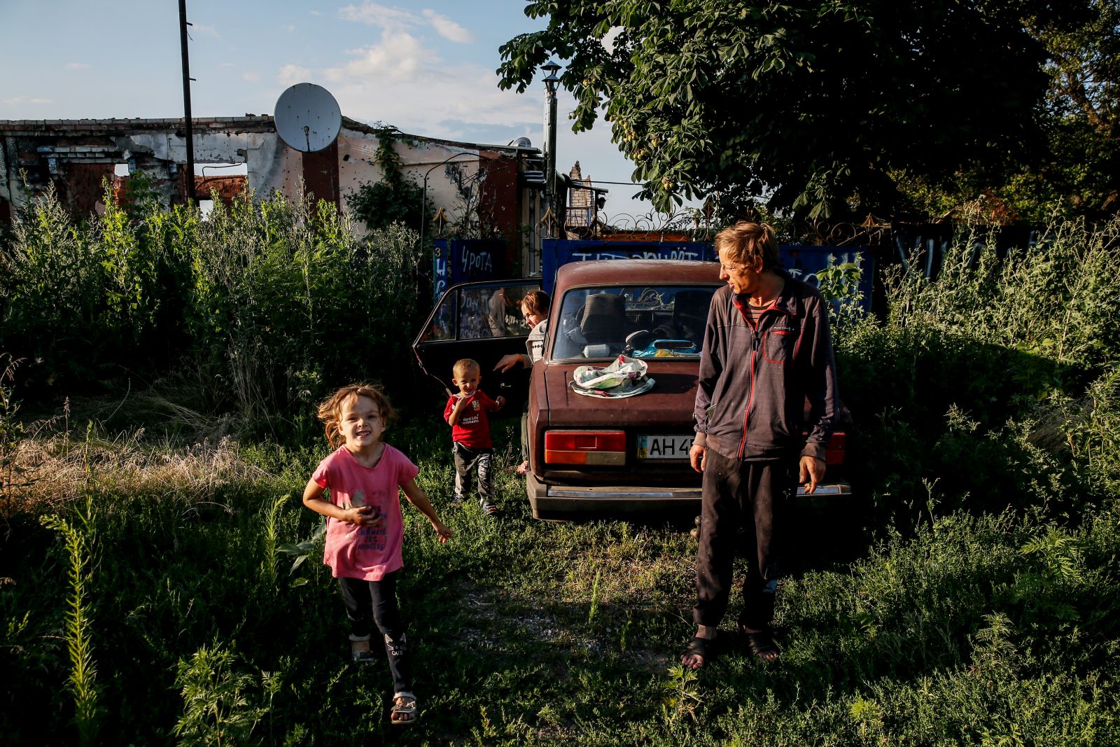 epa10748533 Mykola (41) and his children Artem and Anna walk on the street in Dovhenke village, Kharkiv region, Ukraine, 15 July 2023. Mykola came to his sister's destroyed family home to collect the rest of an apiary damaged during active combat in Russia's ongoing invasion of Ukraine. His own home in nearby Krasnopillia village was also destroyed during the fighting, and he was forced to move with his family to Khrestyshe, where he keeps bees and hopes to one day return home. Russian troops entered Ukraine on 24 February 2022, starting a conflict that has provoked destruction and a humanitarian crisis.  EPA/OLEG PETRASYUK  ATTENTION: This Image is part of a PHOTO SET