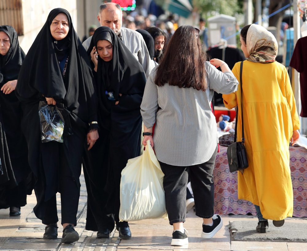 epa10793383 Veiled Iranian women walk next to a woman without wearing headscarf in Tehran, Iran, 10 August 2023. Iran’s President Ebrahim Raisi on 09 August vowed that the Islamic Republic’s mandatory dress code, including laws requiring women to wear the hijab, will be enforced. The statement came a month before the first anniversary of Mahsa Amini’s death in police custody, following her arrest for not wearing the hijab properly. Since then, a growing number of women in the country have been defying authorities by removing the headscarf.  EPA/ABEDIN TAHERKENAREH