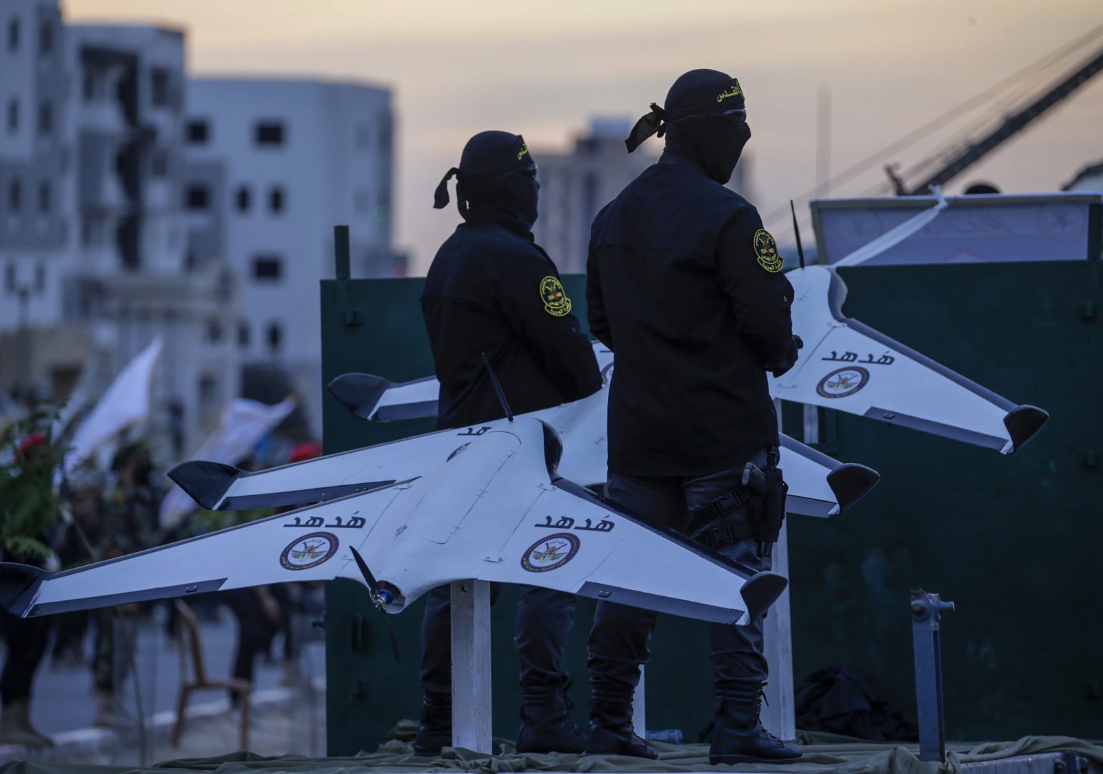 epa10900725 Masked fighters of the Al-Quds Brigades, the armed wing of the Palestinian Islamic Jihad (PIJ) movement, stand on a truck bed next to remote controlled drones as they join a parade to mark the 36th anniversary of the movement's foundation in the southern of Gaza Strip, 04 October 2023.  EPA/MOHAMMED SABER