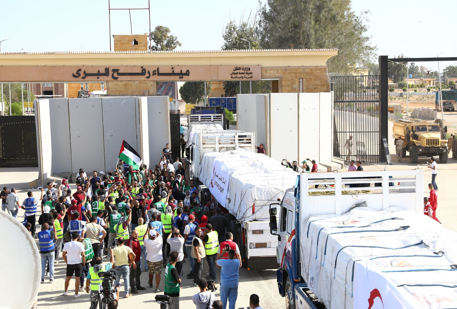 epaselect epa10930319 Trucks carrying humanitarian aid for the Gaza Strip cross the Rafah border gate, in Rafah, Egypt, 21 October 2023. As Egypt is to host, on 21 October, an international summit about Gaza, and following the negotiations between Egypt, the US, and Israel to allow relief aid to enter the Gaza Strip, some 20 aid trucks carrying food, water, and medicine have been allowed into the Gaza Strip through the Rafah land crossing on 21 October. The move comes after days during which trucks were blocked on the Egyptian side of the Rafah border crossing. Egypt's Foreign Ministry had requested that the Isareli strikes on the area near the Gaza side of the border crossing stop, in order to allow the passage of the aid.  EPA/KHALED ELFIQI