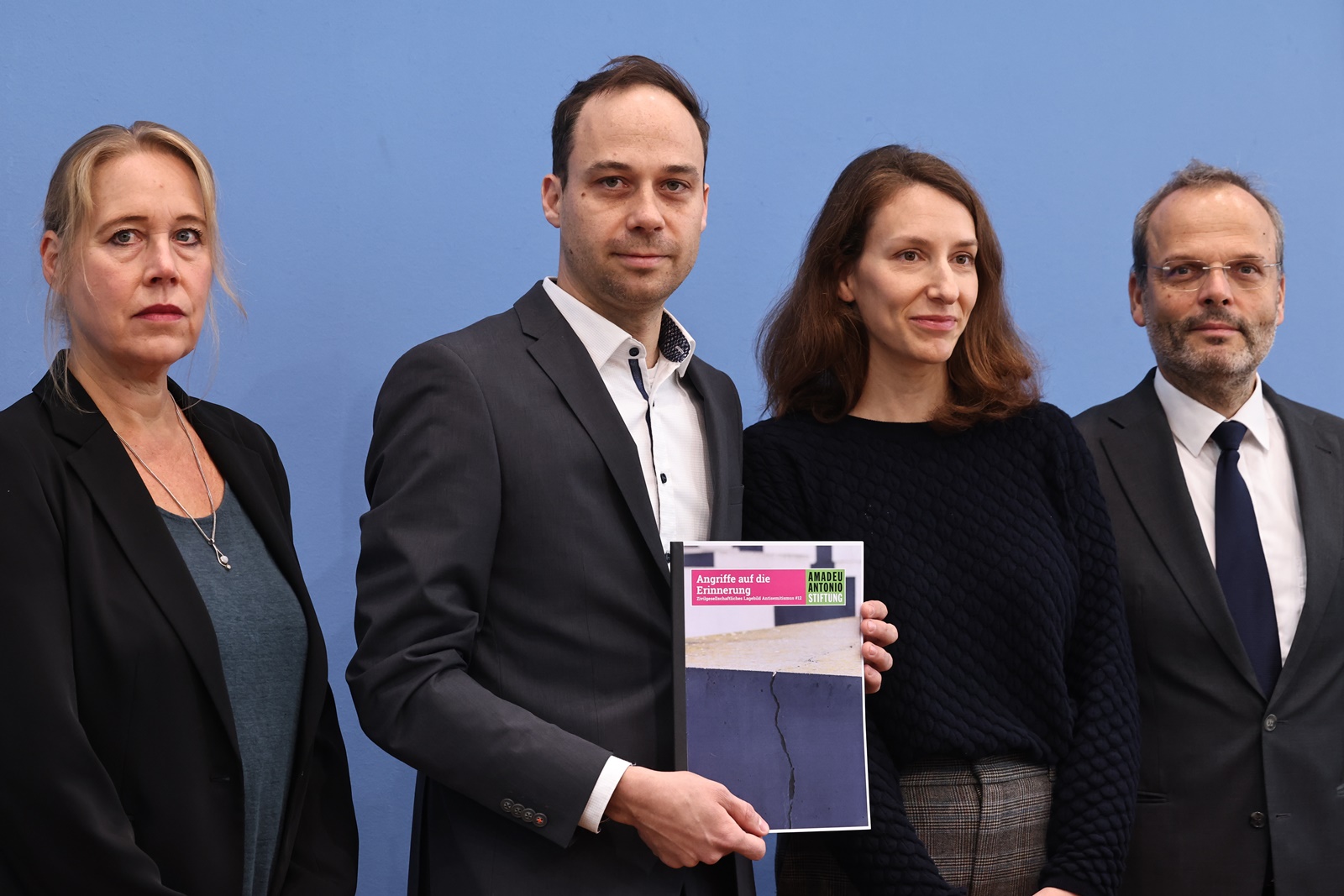 epa10961952 Nikolas Lelle of the Amadeu Antonio Foundation (2-L) holds a report with the title 
'Attacks on remembrance' as he poses with social psychologist and professor of social work, Beate Kuepper (L), Director of the House of the Wannsee Conference Memorial and Educational Site, Deborah Hartmann (3-L), and Federal Government Commissioner for Jewish Life in Germany and the Fight against Anti-Semitism, Felix Klein (R), during a press conference at the Federal Press Conference in Berlin, Germany, 07 November 2023. Federal Government Commissioner for Jewish Life in Germany and the Fight against Anti-Semitism, Felix Klein, presented the 12th edition of the Civil Society Anti-Semitism Situation Report, titled 'Jewish life and the memory of National Socialism are under massive attack'.  EPA/CLEMENS BILAN