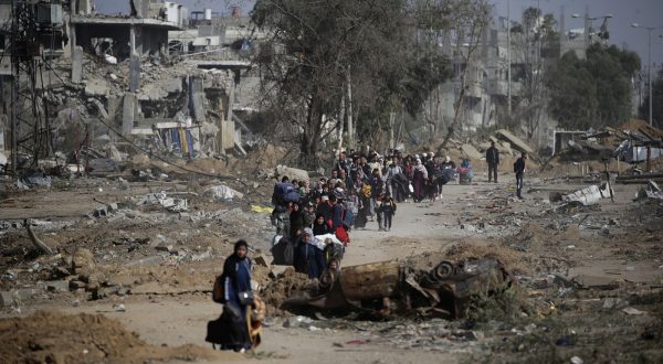 epa10996187 Palestinians walk after crossing from the northern Gaza Strip to the southern Gaza Strip as Israeli tanks (not pictured) move along Salah Al Din road, in the central Gaza Strip, 26 November 2023. After Israel and Hamas agreed to a four-day ceasefire, mediated by Qatar, the US, and Egypt, that came into effect at 05:00 AM GMT on 24 November, some Palestinians who were still in central Gaza moved towards the south while others already displaced in the south went back to the northern part to check on relatives they had left behind and on their homes to collect salvageable belongings. As part of the ceasefire, the agreement included that 50 Israeli hostages, women and children, are to be released by Hamas. 150 Palestinian women and children that were detained in Israeli prisons are to be released in exchange.  EPA/MOHAMMED SABER