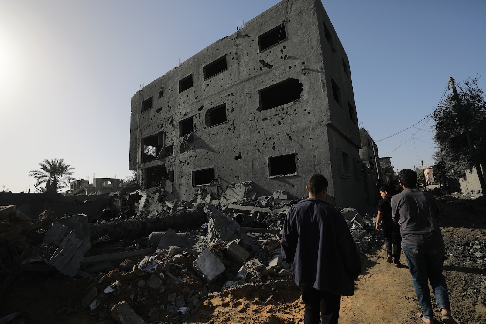 epa10991328 Palestinians walk past the rubble following overnight Israeli airstrikes in the east of Khan Younis, southern Gaza Strip, 23 November 2023. More than 14.000 Palestinians and at least 1,200 Israelis have been killed, according to the Gaza Government media office and the Israel Defense Forces (IDF), since Hamas militants launched an attack against Israel from the Gaza Strip on 07 October, and the Israeli operations in Gaza and the West Bank which followed it.  EPA/MOHAMMED SABER