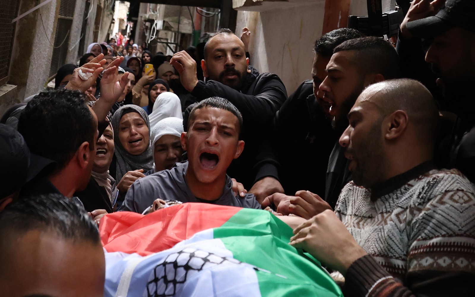 epa11015266 The remains of Palestinian Abed Al Naser Reyahi who was killed in clashes during an Israeli raid on Balata camp on Wednesday 06 December are carried through the streets near the West Bank city of Nablus, 07 December 2023. According to the Palestinian Health Ministry, one Palestinan  was killed and five others injured during the raid.  EPA/ALAA BADARNEH