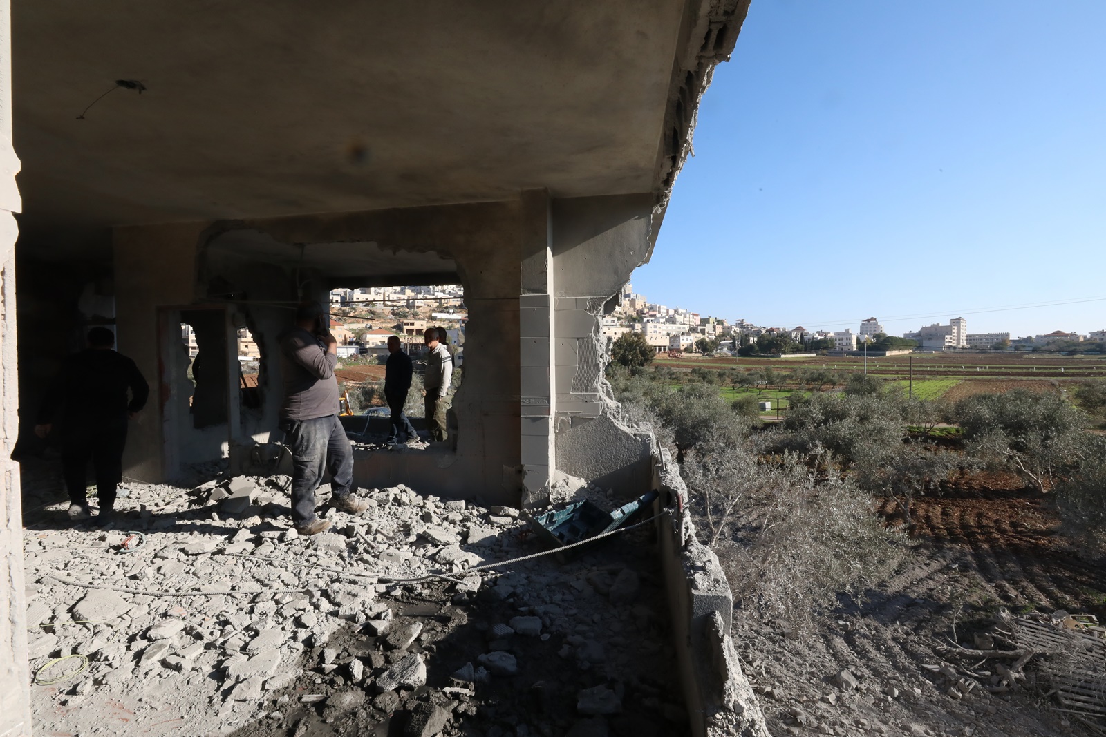 epa11036863 Palestinians inspect the destroyed home of Osama Bani Fadel in Aqraba village, south of the West Bank city of Nablus, 19 December 2023. The Israeli army demolished the house of Osama Bani Fadel, the alleged gunman named responsible for a shooting attack in Huwwara village near Nablus that killed two Israelis in August.  EPA/ALAA BADARNEH