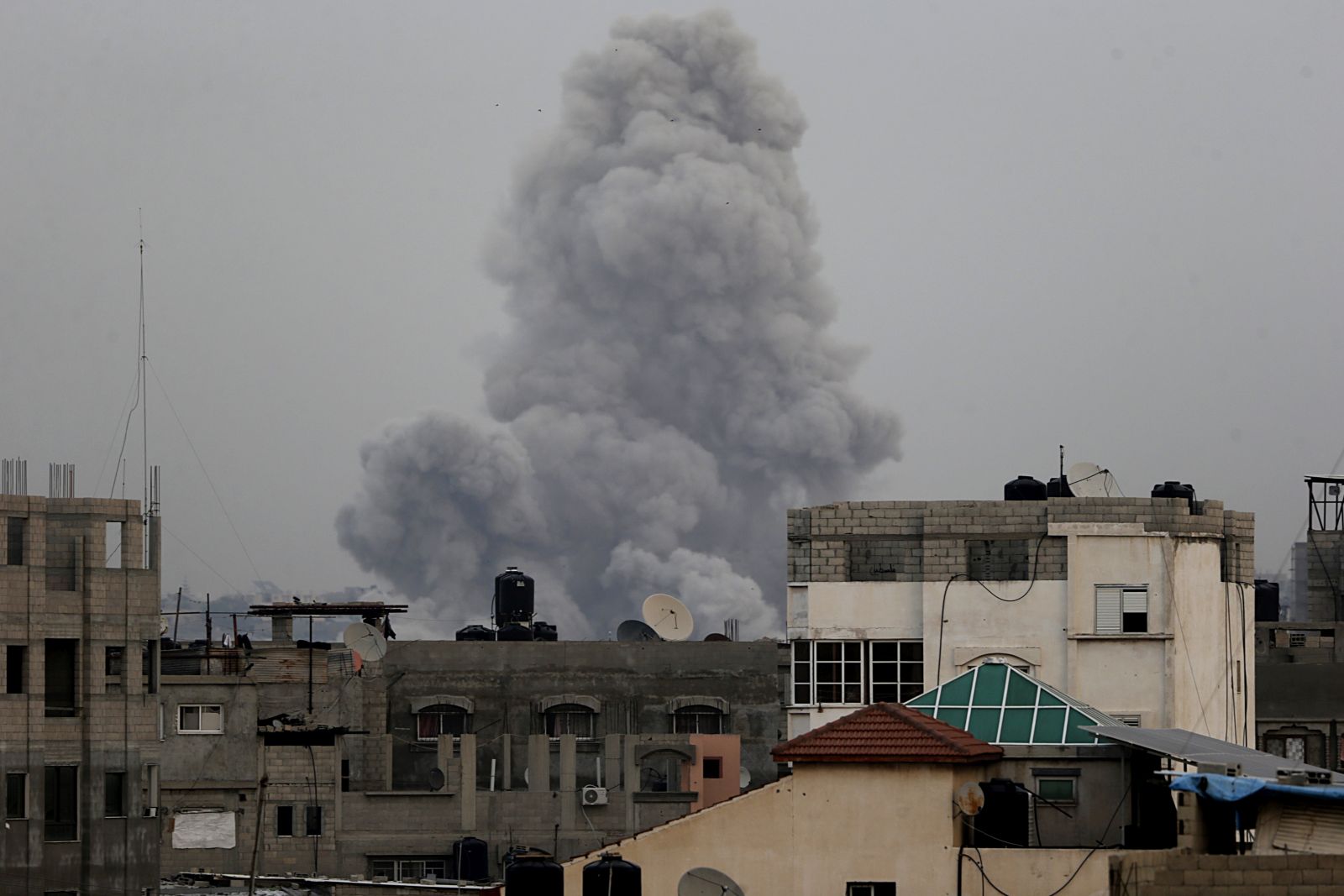 epa11040023 Smoke rises over residential buildings following an Israeli airstrike in the town of Khan Younis, southern Gaza Strip, 21 December 2023. More than 19,600 Palestinians and at least 1,200 Israelis have been killed, according to the Palestinian Health Ministry and the Israel Defense Forces (IDF), since Hamas militants launched an attack against Israel from the Gaza Strip on 07 October, and the Israeli operations in Gaza and the West Bank which followed it.  EPA/MOHAMMED SABER