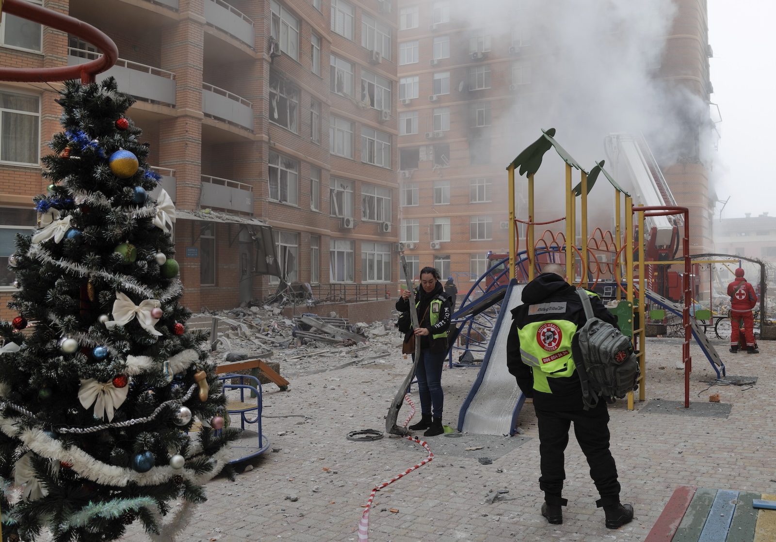 epa11048265 A Christmas tree near a playground as Ukrainian rescuers and police officers work at the site of a damaged residential building after shelling in Odesa, southwestern Ukraine, 29 December 2023, amid the Russian invasion. At least 18 people have died and over 130 were injured after Russia launched a wave of airstrikes across Ukraine, Ukraine's Ministry of Internal Affairs said on 29 December. Strikes were reported in Kyiv, Lviv, Odesa, Dnipro, Kharkiv, Zaporizhzhia, and other Ukrainian cities. Russia launched 'more than 150 missiles and combat drones' at Ukrainian cities, Ukraine's Prosecutor General Andriy Kostin said in a statement, adding that extensive damage included residential buildings, educational institutions and hospitals. Russian troops entered Ukraine on 24 February 2022 starting a conflict that has provoked destruction and a humanitarian crisis.  EPA/IHOR HORA